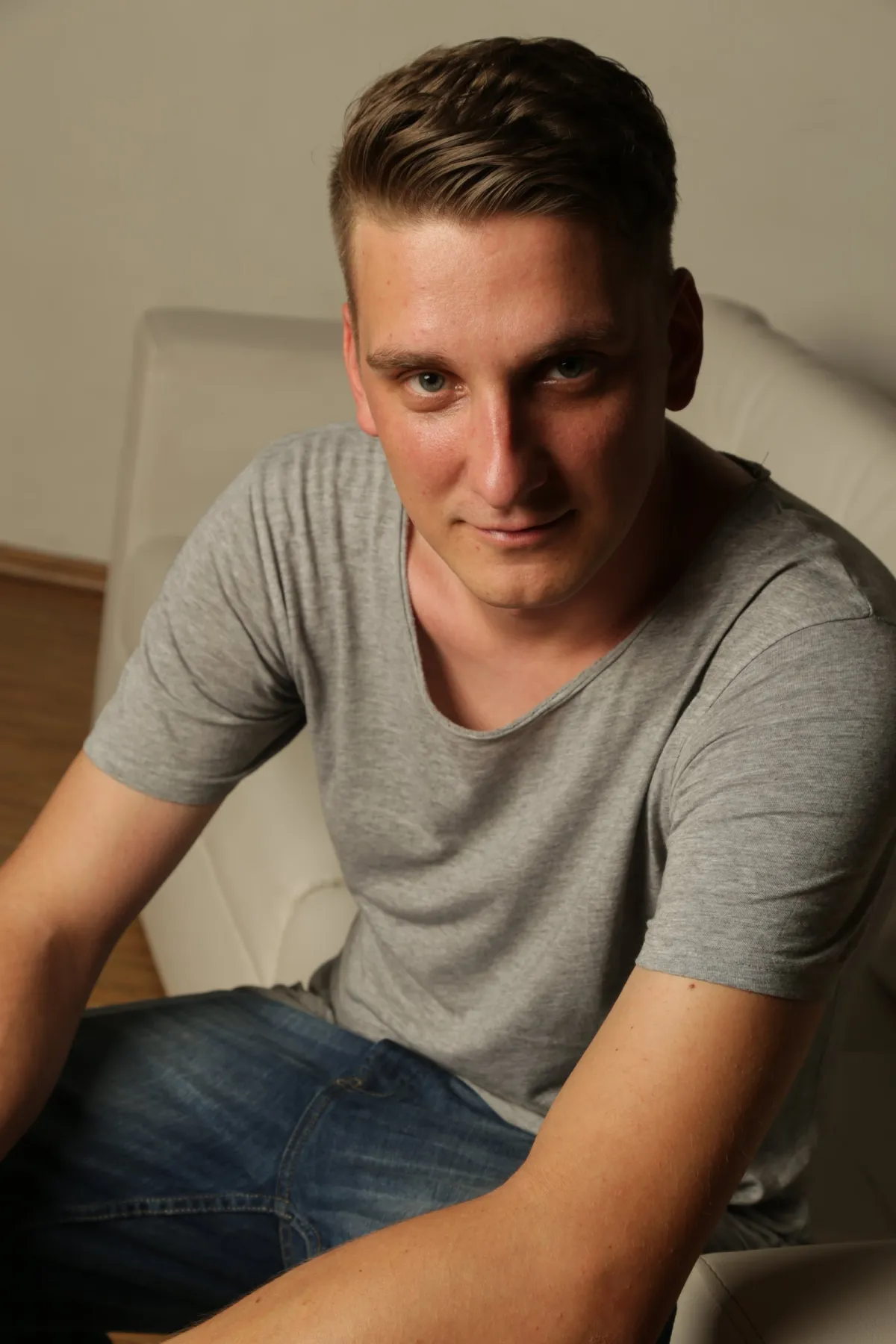 DJ EMC sitzt entspannt auf einem weißen Sessel und schaut in die Kamera